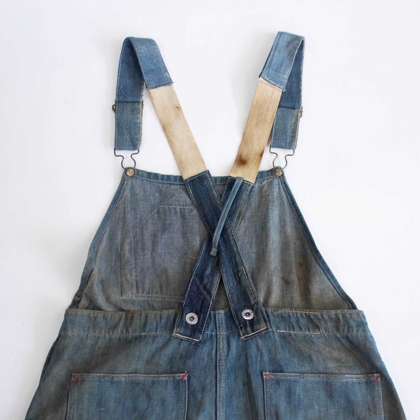 Early 1900s overalls with strap extension.